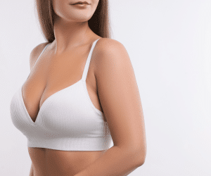 A woman, who have done breast lift procedure, wearing a white bra