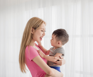 A mom holding her child while smiling at the child