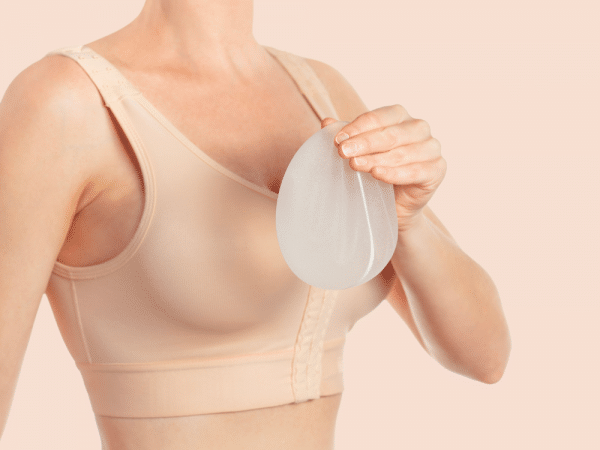 Woman wearing compressing bra which is common after a breast augmentation surgery